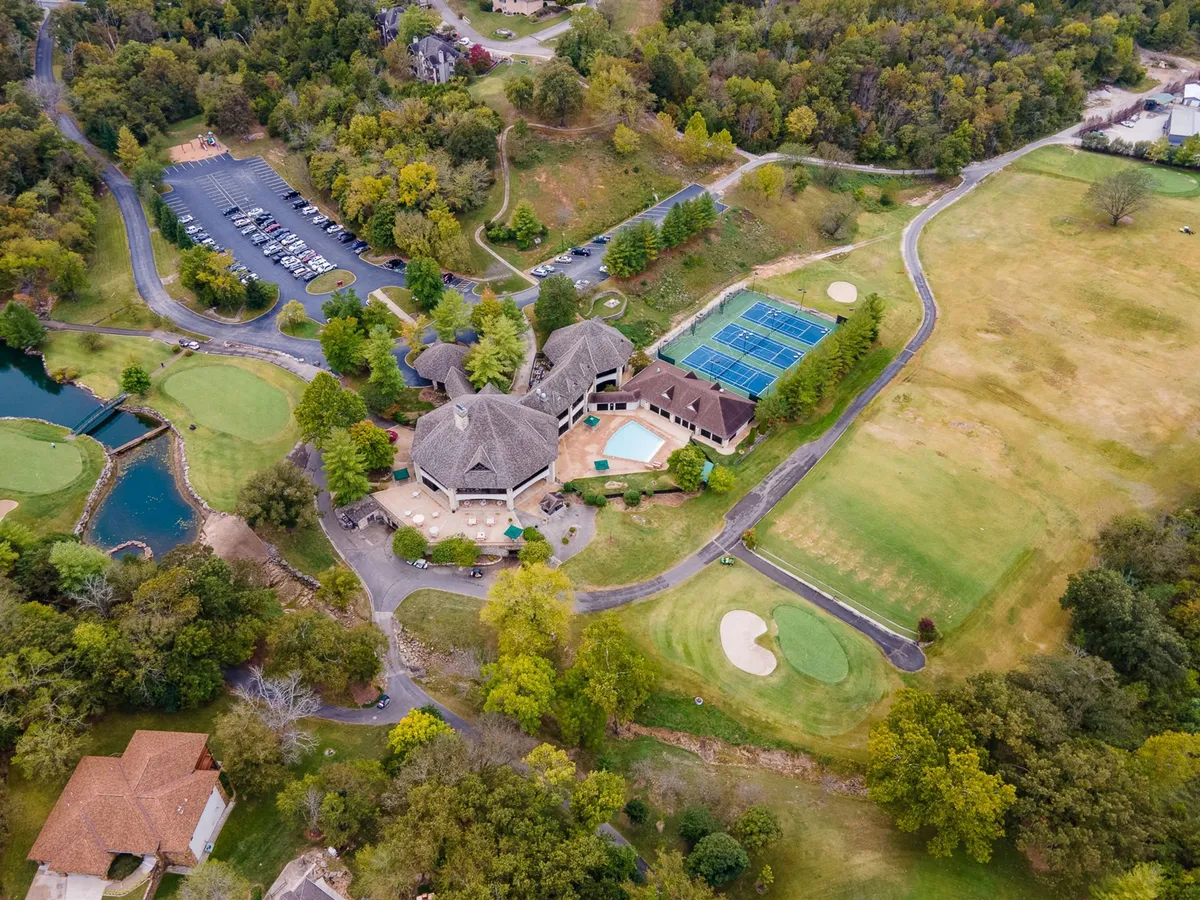 Expansive resort amenities including a lush golf course, tennis courts, a sparkling swimming pool, and a welcoming clubhouse. The scene is lively yet peaceful, inviting guests to explore, play, and unwind together.